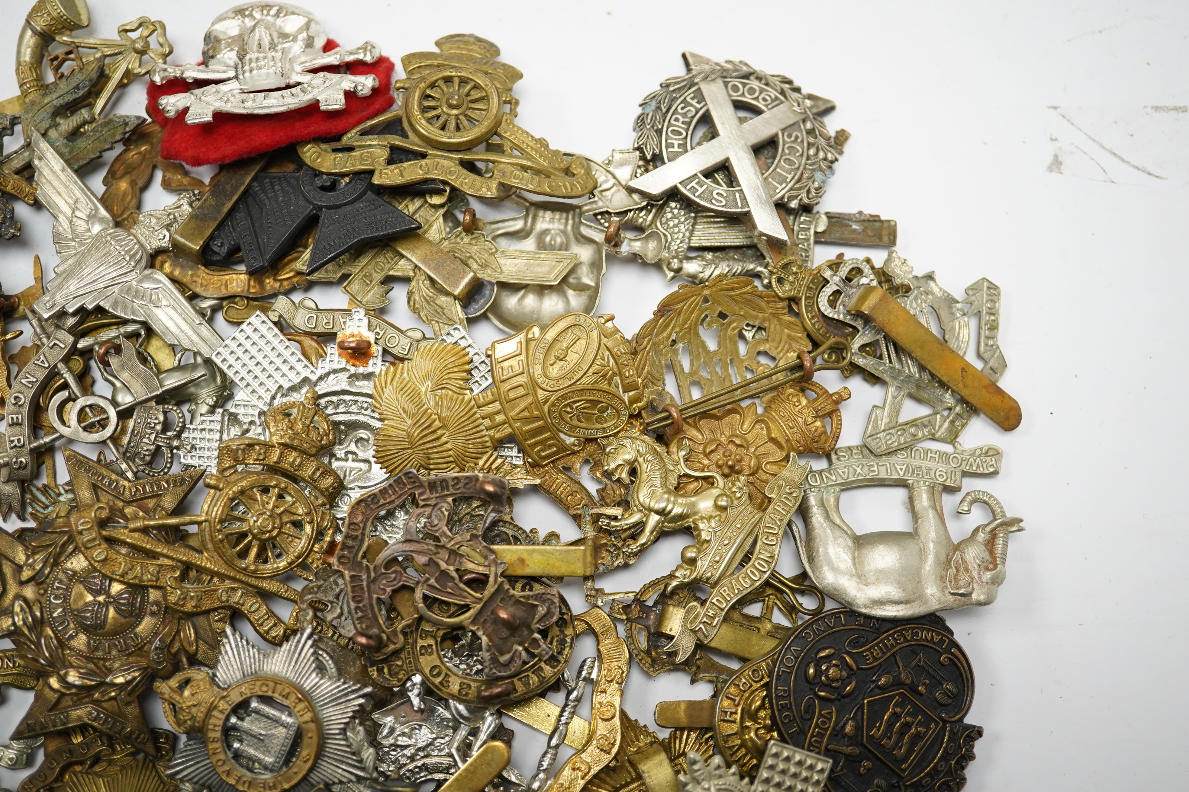 Sixty military cap badges, including; the Brecknockshire Regiment, the Royal Warwickshire Regiment, the South Lancashire Prince of Wales Volunteers, the Royal Artillery, the East Lancashire Regiment, the Glider Pilot Reg